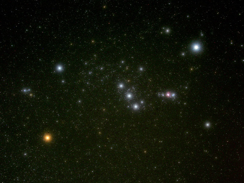 Im Bild ist das Sternbild Orion zu sehen, links unten leuchtet der orangefarbene Stern Betelgeuse, in der Mitte befindet sich der diagonale Gürtel, rechts daneben das Schwert mit dem Orionnebel, und links oben strahlt der helle Stern Rigel.