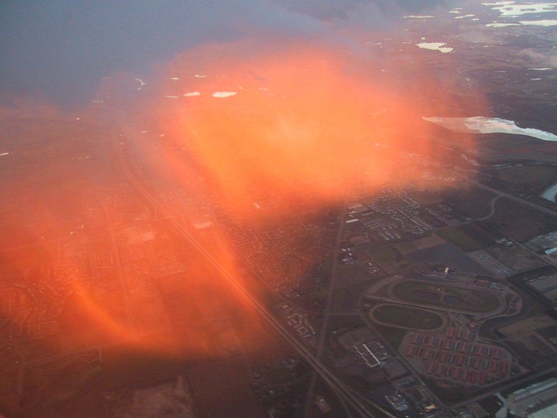 Das Bild zeigt eine rot leuchtende Wolke, die von einem Flugzeug aus beobachtet wurde.