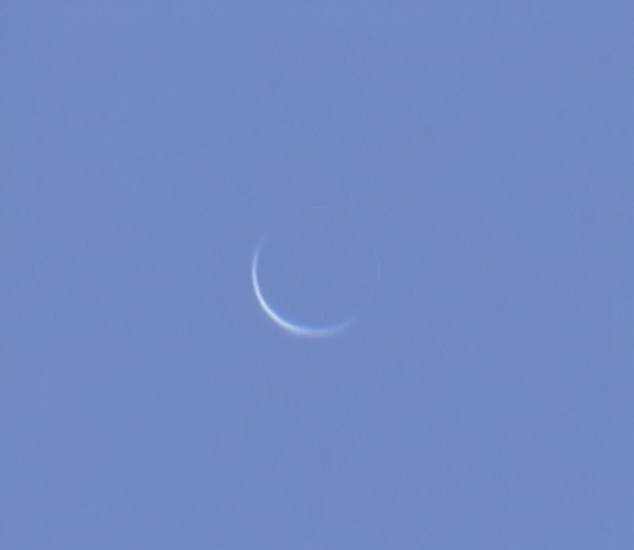 Auf einem blauen Himmel leuchtet eine sehr schmale Venussichel.