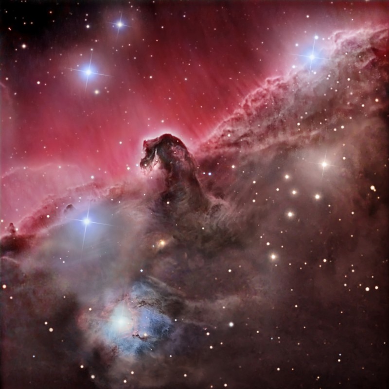 Mitten im Bild ist die berümhte Dunkelwolke Pferdekopfnebel. Dahinter ist ein rötlich leuchtender, gestreifter Nebel, rechts unten ist eine Dunkelwolke mit einigen hellen Sternen, und rechts unten leuchtet der Nebel um einen Stern herum bläulich.