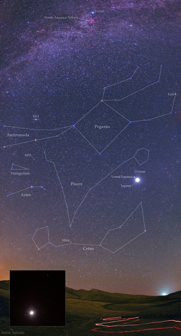 Am sternklaren Himmel sind Sternbilder markiert: Andromeda, Pegasus, Fische, Dreieck, Widder, Walfisch. Unten ist eine Berglandschaft mit einem Weg, auf dem ein rotes Licht entlanggetragen wurde. In den Fischen leuchtet der Planet Jupiter. Links unten ist ein Bildeinschub mit dem vergrößerten Jupiter und seinen Monden.