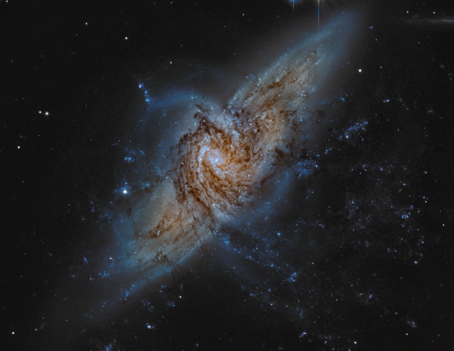 Zwei Galaxien im Bild liegen zufällig in einer Sichtlinie und bilden einen dichten Wirbel aus Sternen und Staub.