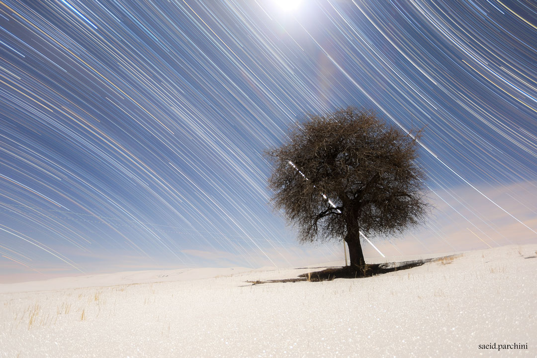 Strichspuren der Sterne über einer einsamen verschneiten Landschaft im Iran zeigen den Himmelsäquator; Ein Klick auf das Bild lädt die höchstaufgelöste verfügbare Bildversion.
