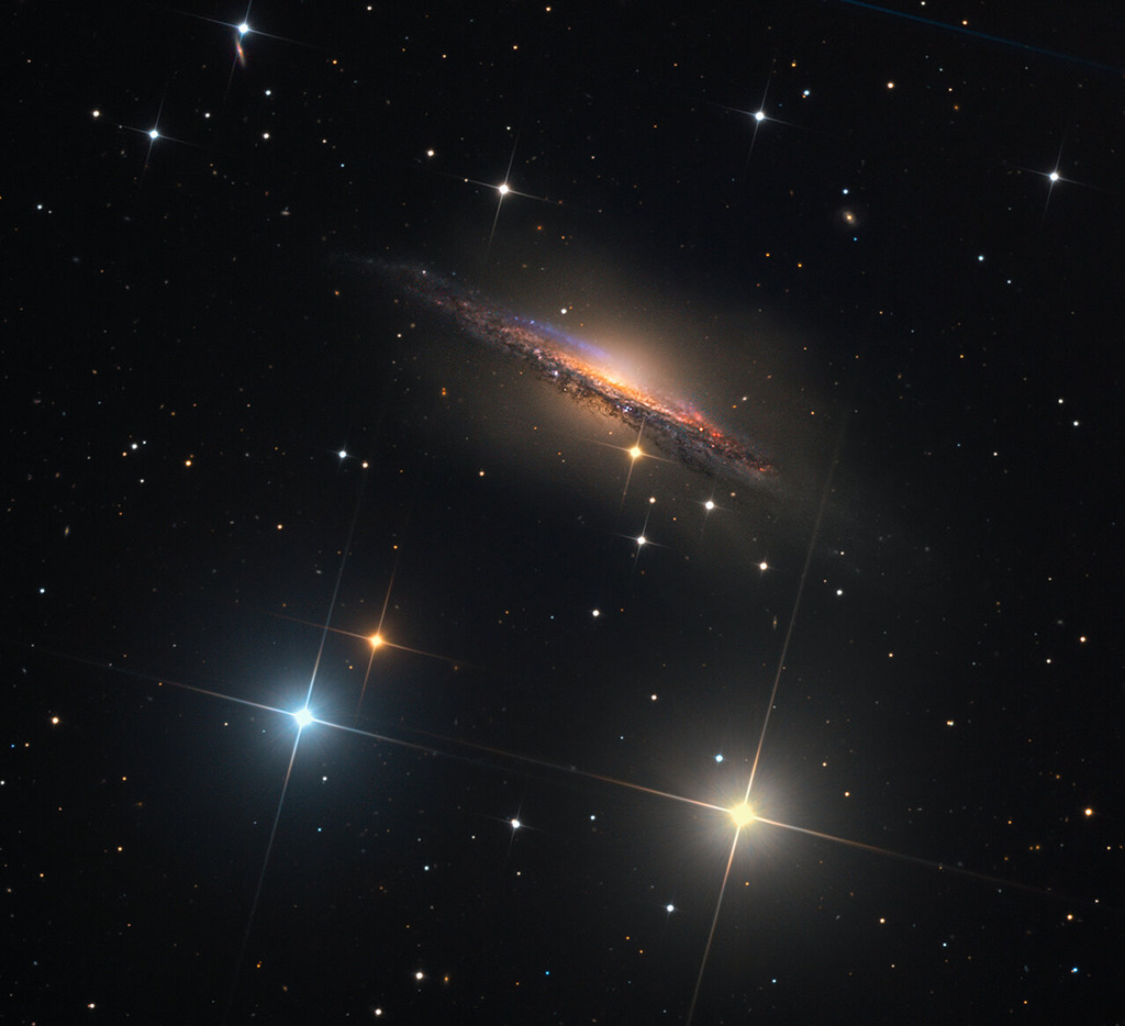 Die Spiralgalaxie NGC 1055 ist ein markantes Mitglied einer kleinen Galaxiengruppe, die ungefähr 60 Millionen Lichtjahre entfernt im Sternbild Walfisch (Cetus) liegt.