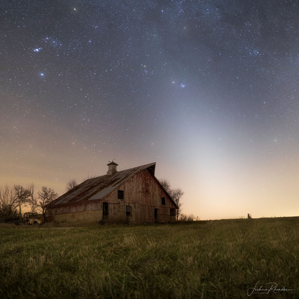 Zodiakallicht umhüllt am Abend Mars und die Plejaden über einer alten Scheune in Illinois.