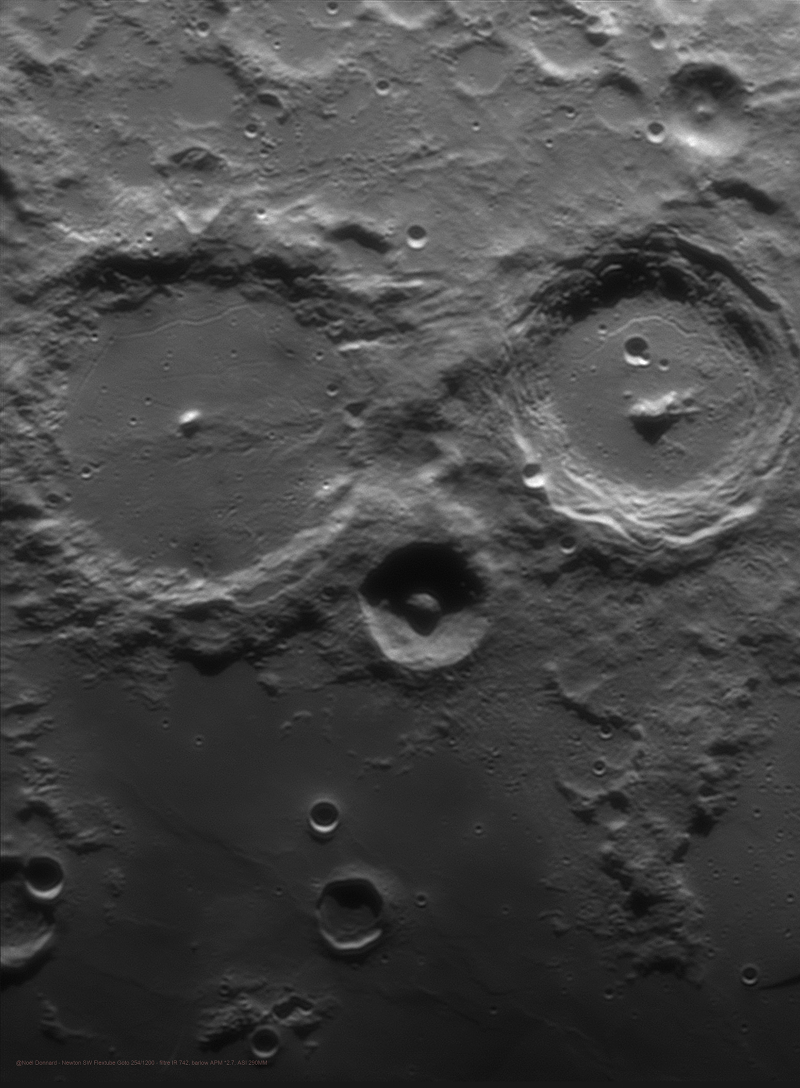 Der eulenartige Blick der Mondkrater Alphonsus, Arzachel und Alpetragius an der Licht-Schatten-Grenze an der Küste des Mare Nubium, dem Wolkenmeer.