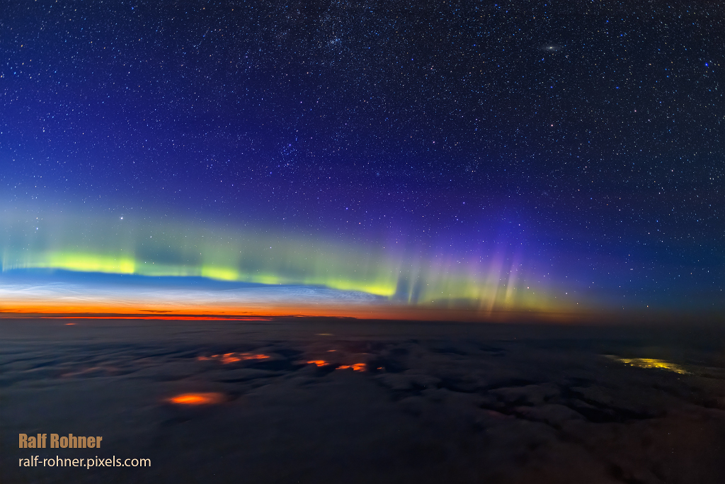 Polarlichter und leuchtende Nachtwolken am Rande des Weltraums.