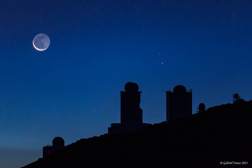 Mondsichel mit Erdschein, Merkur und Zeta Tauri im Sternbild Stier hinter den Sonnenteleskopen auf der Kanarischen Insel Teneriffa.