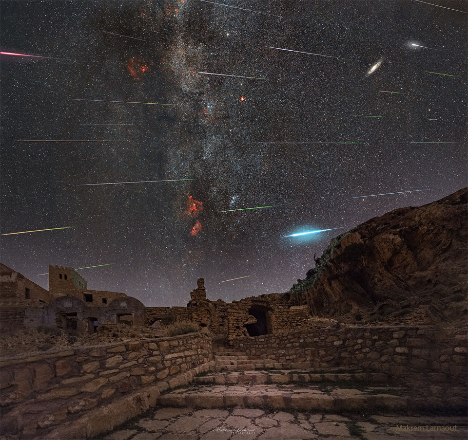 Das zusammengesetzte Bild zeigz viele Meteoritenstreifen über den Ruinen eines alten Dorfes.
