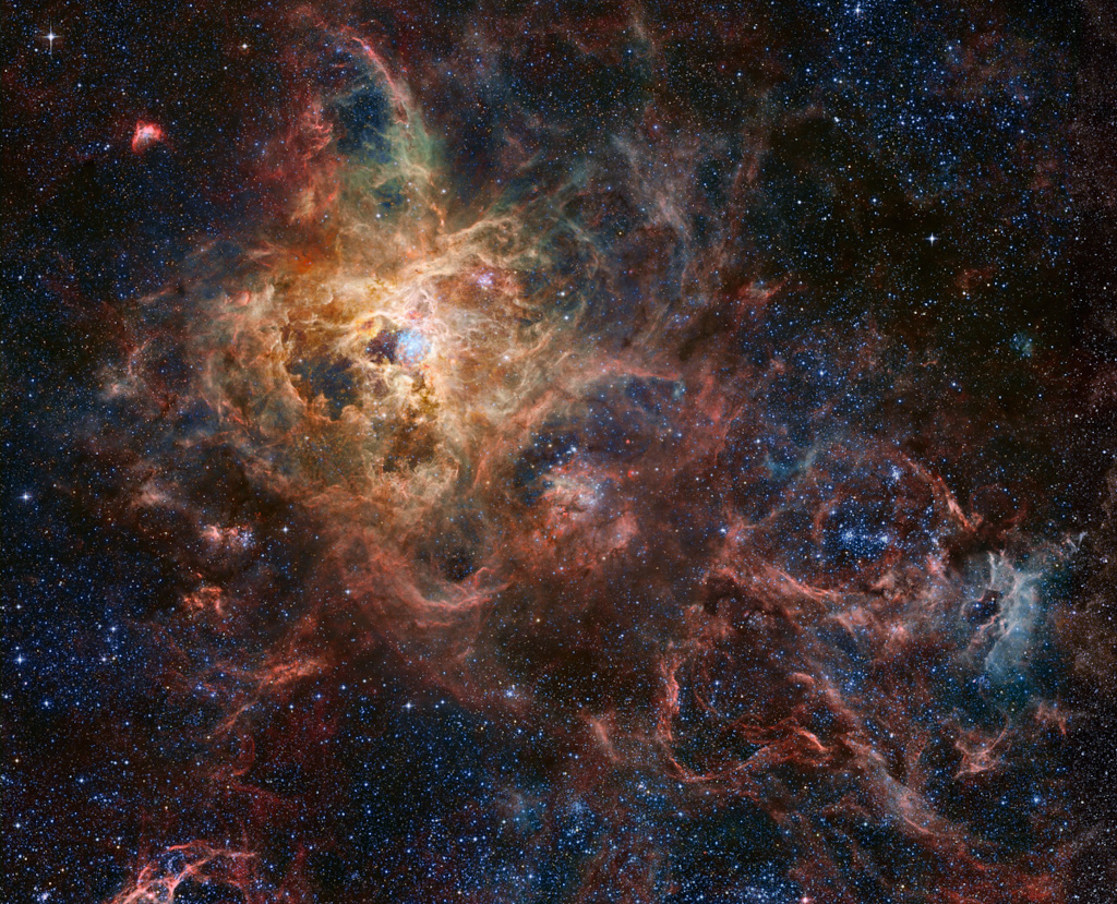 Das Bild ist eine Montage aus Bilddaten von Teleskopen im Weltraum und auf der Erde, es zeigt den Tarantelnebel in der Großen Magellanschen Wolke.