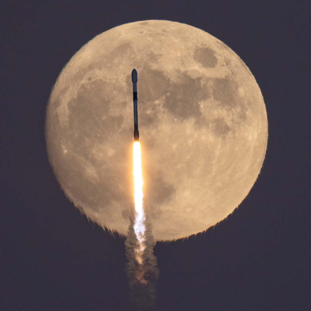 Startende Falcon-9-Rakete durchstößt den aufgehenden Vollmond über Florida.