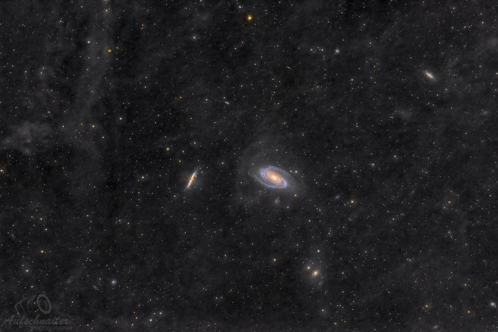 Mitten im Bild leuchten die markanten Galaxien M81 und M82, im Hintergrund sind weitere Galaxien zu sehen, wie etwa NGC 3077 und NGC 2976.