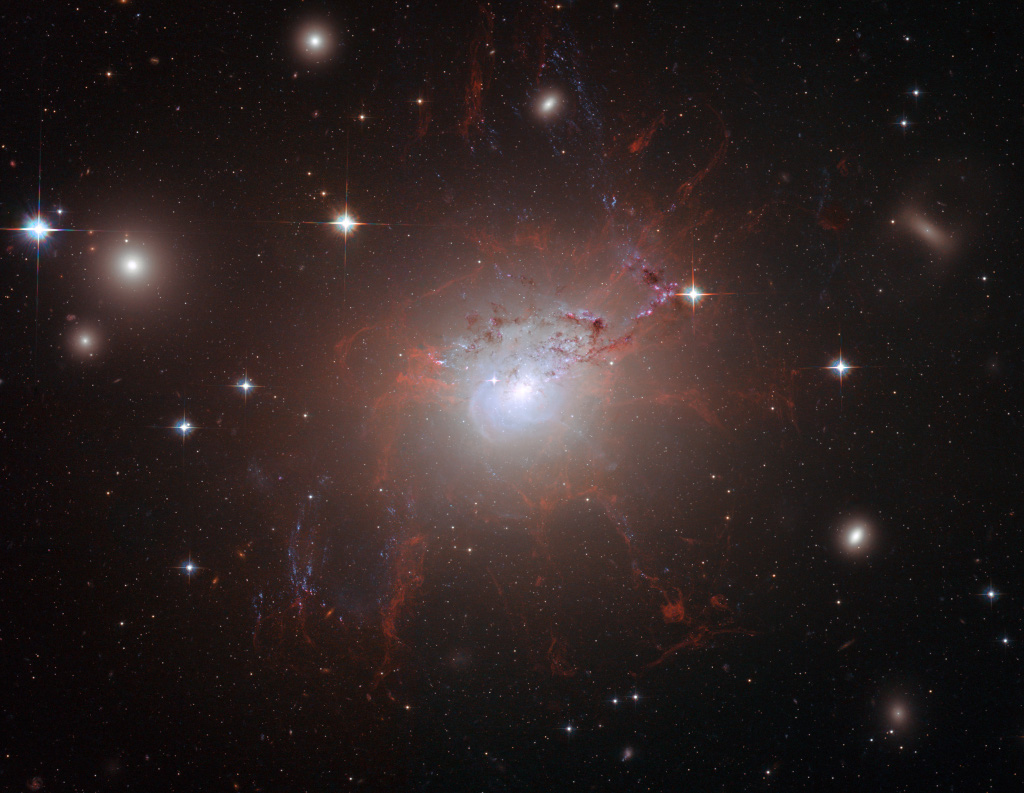 Die aktive Galaxie NGC 1275 ist eine starke Röntgenquelle, im sichtbaren Licht sehen wir unzählige Fasern und Filamente, die von hineinstürzenden Galaxien übrig geblieben sind.