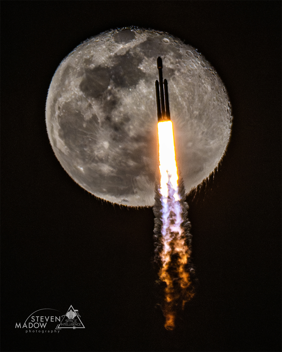 Vor einem riesengroßen Mond startet eine Rakete mit zwei Boostern. Der untere Rand des Mondes sieht aus, als wäre er geschmolzen und würde hinuntertropfen.