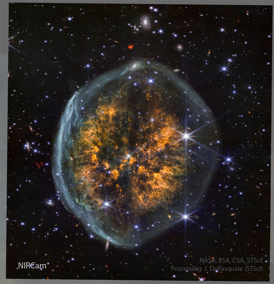 Ein Sternenfeld umgibt einen Nebel, der an ein Gehirn erinnert. Im Inneren des blauen äußeren Ovals liegt eine helle Nebelwolke.