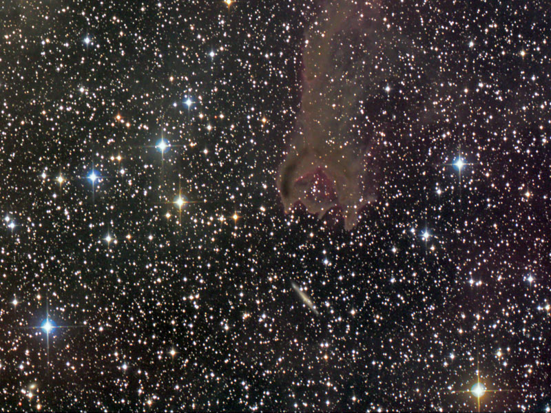 Die kometenartige Globule CG4 im Sternbild Puppis (Achterdeck des Schiffes) scheint eine Galaxie zu fressen, diese liegt jedoch weit dahinter und ist riesig.