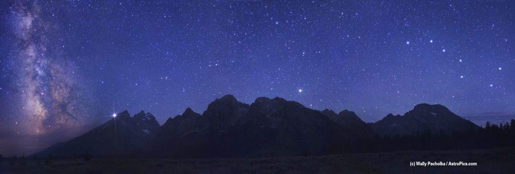 Über der Teton Range in den USA, die zu den Rocky Mountains gehört, leuchten die Milchstraße, der Planet Jupiter, der helle Stern Arkturus und der Große Wagen.