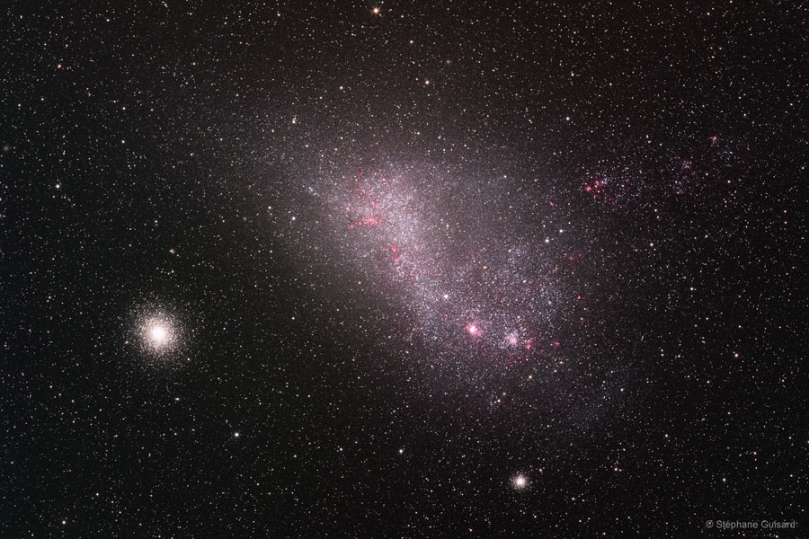 Die kleine Magellansche Wolke wirkt im Bild irregulär, links daneben und darunter sind zwei Kugelsternhaufen zu sehen.