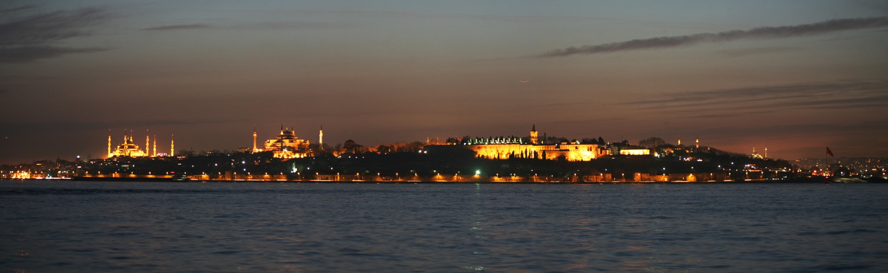 Über der Silhouette von Istanbul in der Türkei befindet sich über dem Topkapi-Palast eine sehr schmale Mondsichel.
