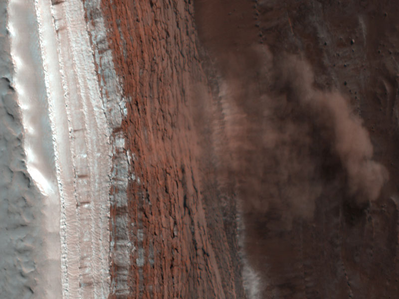 Eine Lawine stürzt auf dem Mars über einen Abhang und wirbelt so viel Staub auf, dass die Staubwolke einen Schatten wirft.