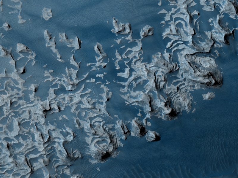 Diese Felsnasen auf der Marsoberfläche sind in Falschfarben-Blau dargestellt, sie erinnern an Ozeanwellen.