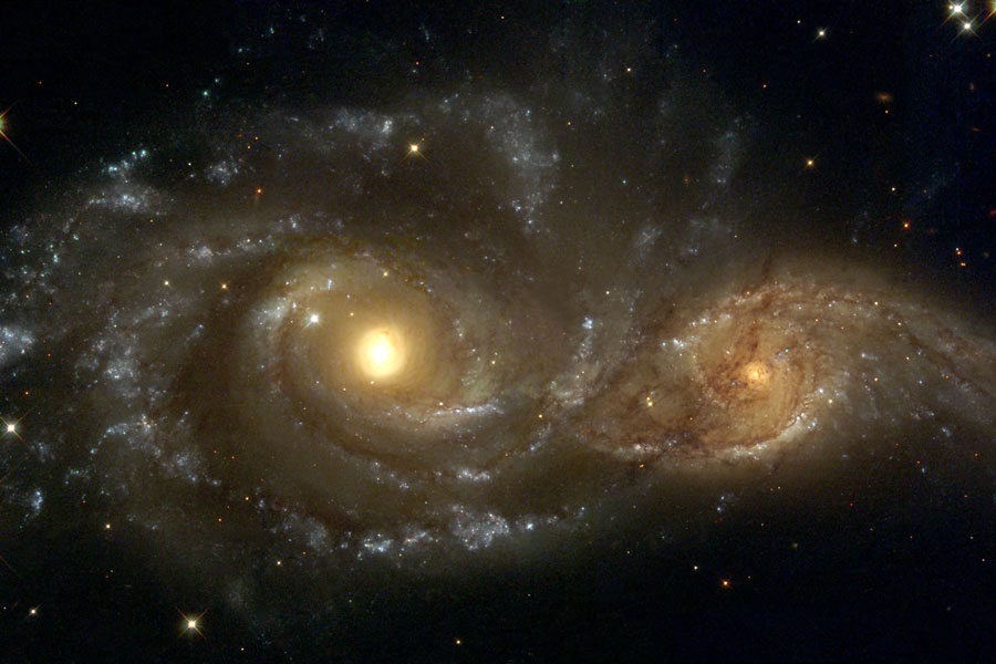 Zwei gelbe Galaxien leuchten auf einem dunklen Hintergrund, sie erinnern an unheimliche Augen.