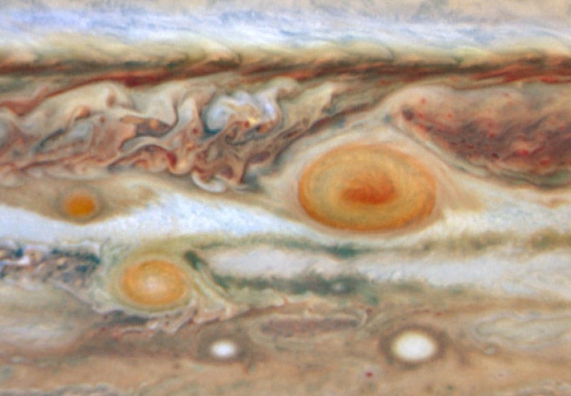 Das Bild zeigt einen Äquatorgürtel auf Jupiter in starker Vergrößerung, in dem starke Wirbelstürme erkennbar sind. Außer dem Großen Roten Fleck sind noch zwei weitere rote Sturmgebiete erkennbar sowie zwei weiße Ovale.