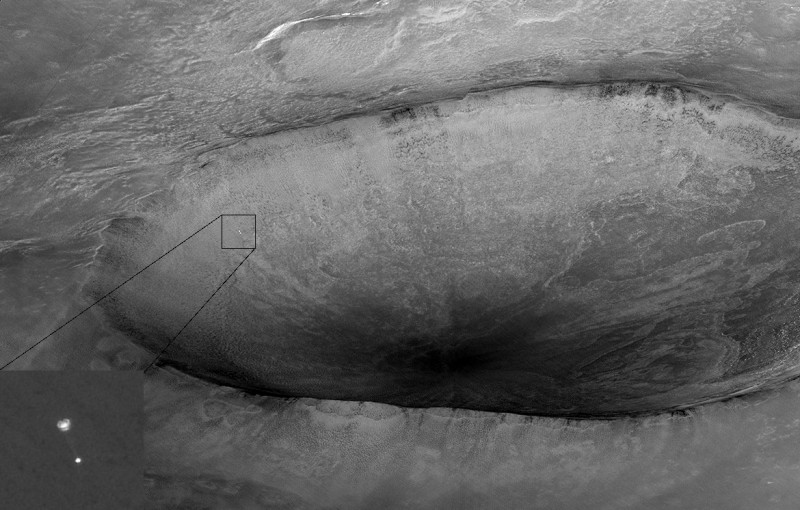 Das Bild zeigt, wie die Landesonde Phoenix am Fallschirm in den Krater Heimdall absteigt.