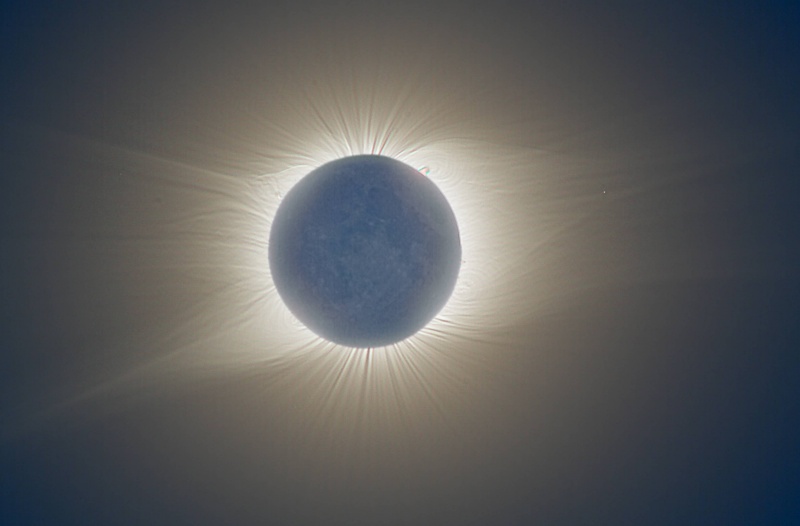 Rund um die Nachtseite des Mondes leuchten die Strahlen der Sonnenkorona bei einer Sonnenfinsternis.