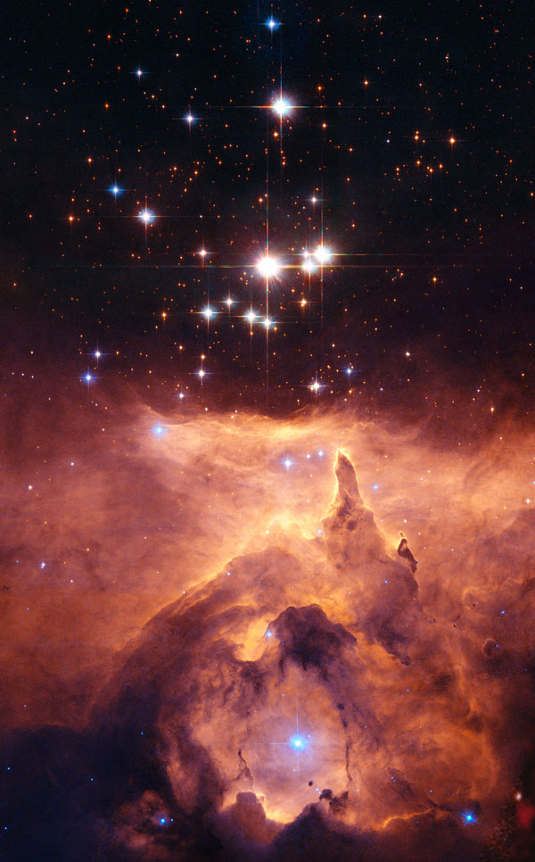 Im unteren Bildteil leuchtet ein orangefarbener Nebel, darüber ein Sternhaufen mit relativ wenigen Sternen.
