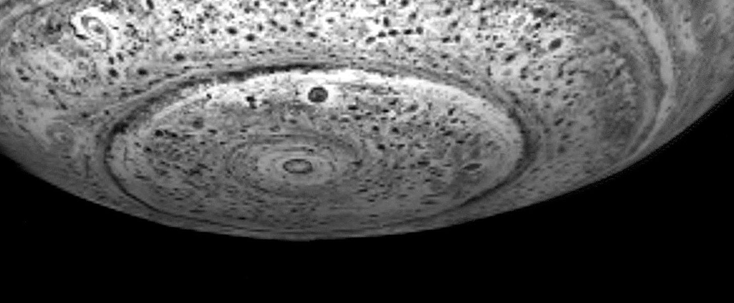 Das Schwarzweißbild zeigt die Unterseite von Saturn - eine Polregion mit ringförmigen und blasenähnlichen Strukturen.