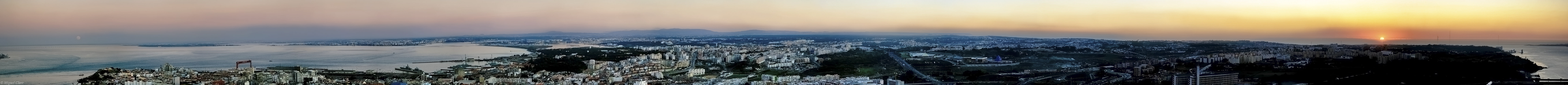 Das Bild ist ein sehr breites Panorama mit Blick über Lissabon, rechts geht die Sonne unter, links geht der Mond auf.