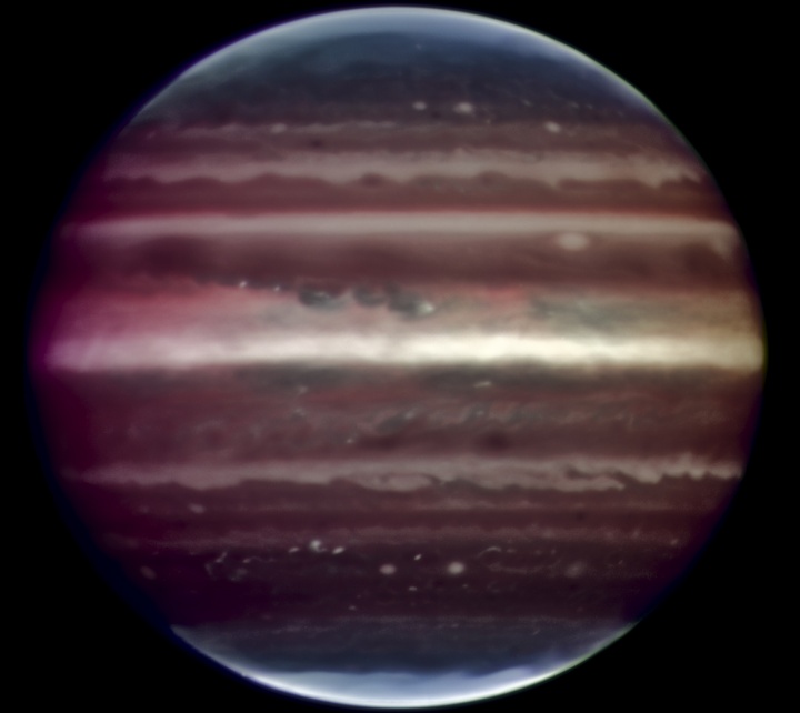 Der Planet Jupiter ist als dunkler Kreis mit einigen waagrechten helleren Gürteln bildfüllend dargestellt.