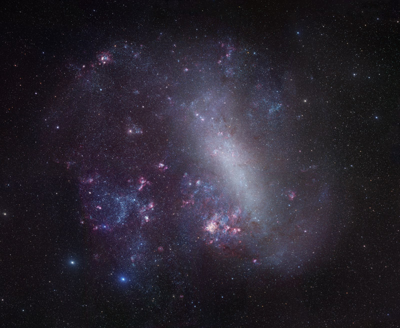 Die Große Magellansche Wolke ist bildfüllend abgebildet, in der Mitte verläuft diagonal eine helle balkenähnliche Sternansammlung, in der Galaxie sind rosarote Sternbildungsregionen verteilt.