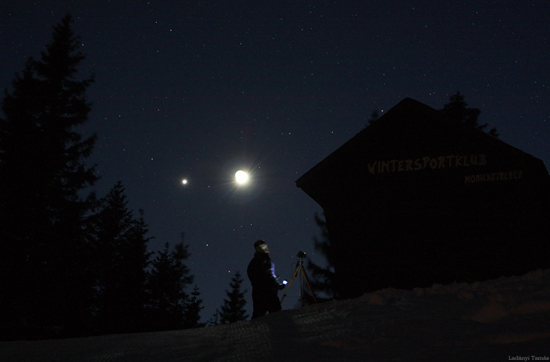 Auf einem sehr dunklen Hintergrund leuchtet neben dem hellen Mnd leuchtet die Venus.