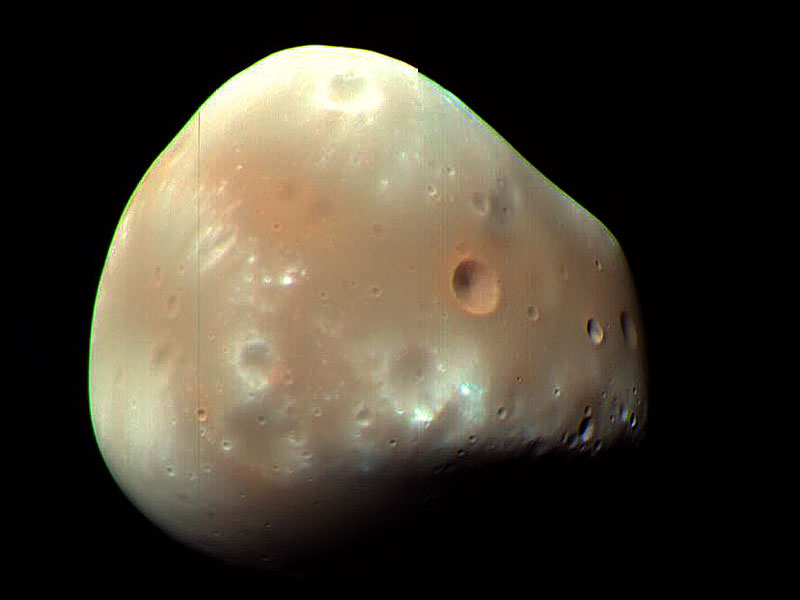 Ein glatter, rötlich-brauner, kartoffelartiger Himmelskörper ist von wenigen Kratern bedeckt.