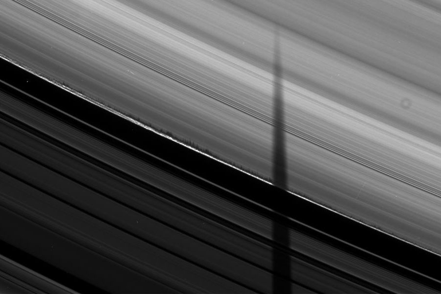 Über diesen Ausschnitt der Saturnringe verläuft eine lange, dunkle Scharte quer über die Rillen.