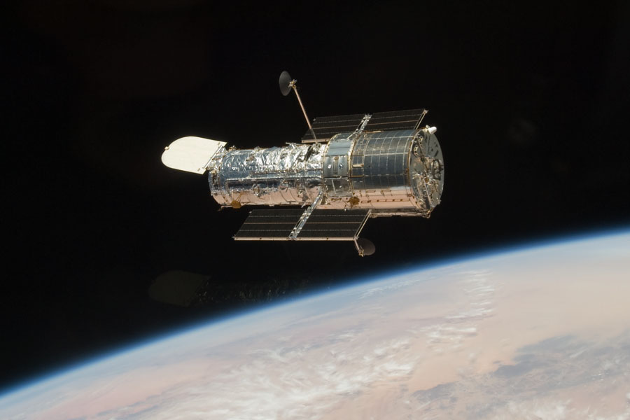 Das Weltraumteleskop Hubble schwebt über der Erde.