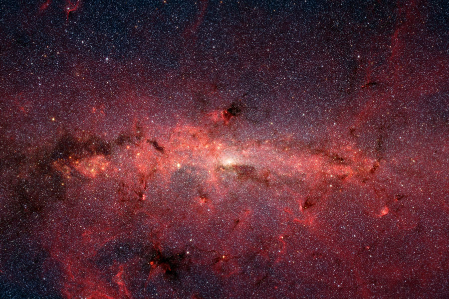 Dieser Ausschnitt der Milchstraße ist voller Sterne, übersät von roten und dunklen Nebeln.