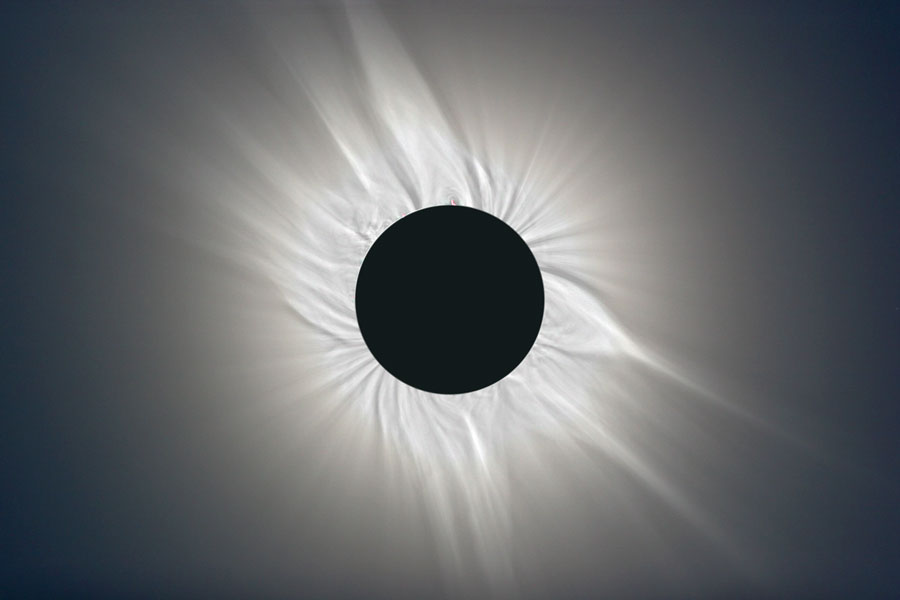 Die dunkle Scheibe in der Mitte ist der Mond, der die Sonne verdeckt, er ist von einer gefaserten Sonnenkorona umgeben.