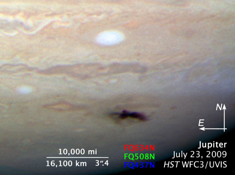 Auf Jupiters Oberfläche ist oben ein weißes Oval und darunter ein dunkler Fleck zu sehen, der von einem Einschlag stammt.