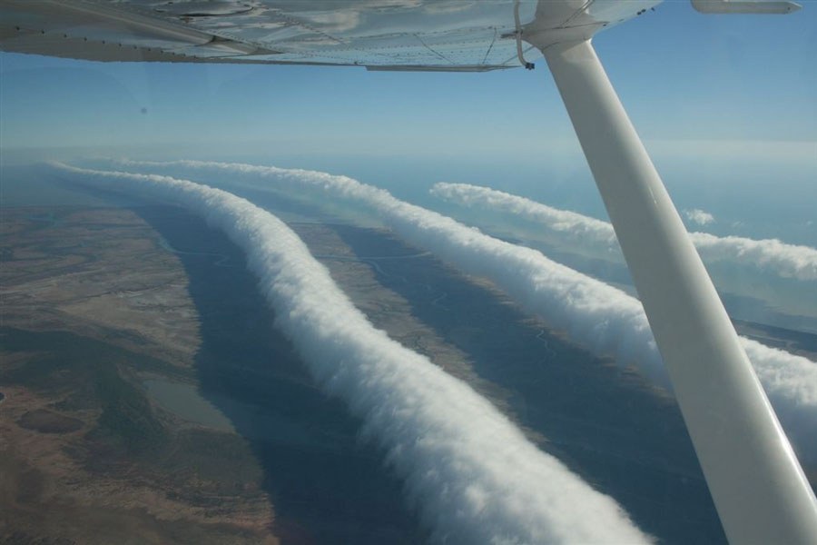 Unter dem Flügel eines Kleinflugzeugs sind walzenförmige Wolkenwülste zu sehen.