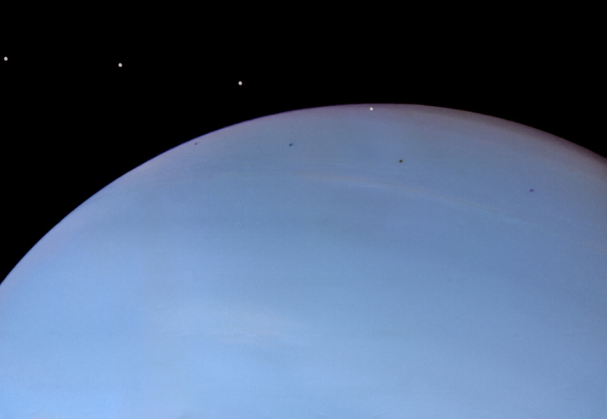 Unten ist ein Teil des blauen Planeten Neptun zu sehen, davor sind vier Lichtpunkte erkennbar. Das Bild ist ein Komposit aus mehreren Aufnahmen der Raumsonde Voyager 2, das den Mond Despina zeigt.