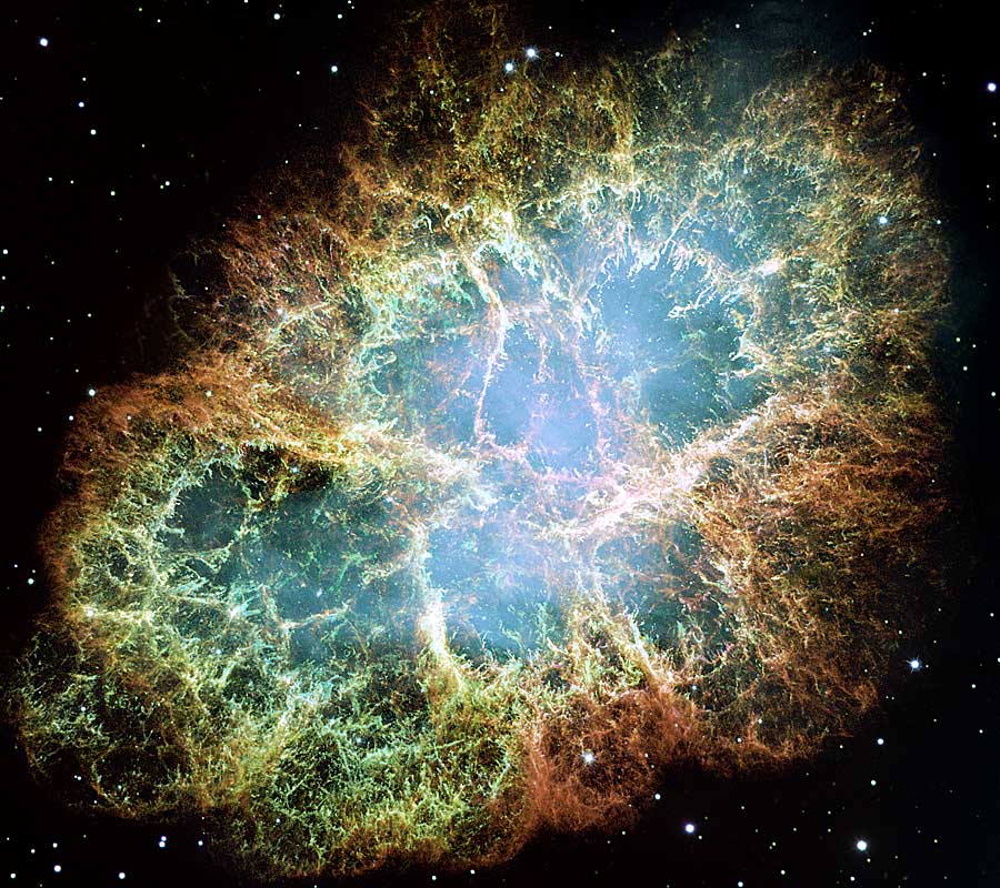 Fast bildfüllend ist das erste Messier-Objekt abgebildet: der Krebsnebel M1 im Sternbild Stier. Er ist stark gefasert und hier in grünlichen Farbtönen dargestellt.