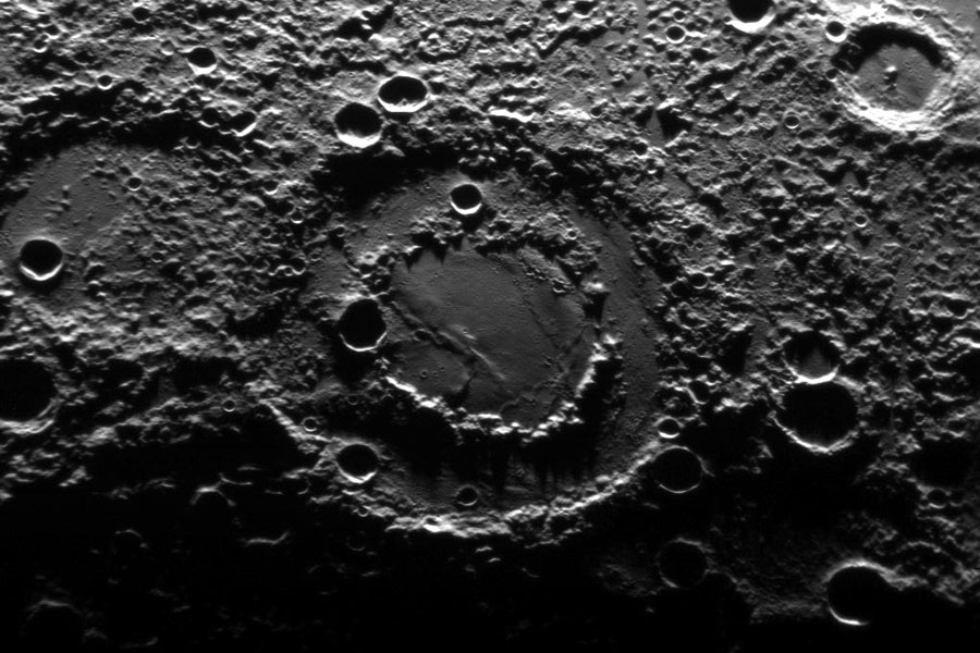 Mitten im Bild ist ein Becken mit Doppelring in eine kraterübersäte Oberfläche gegraben.