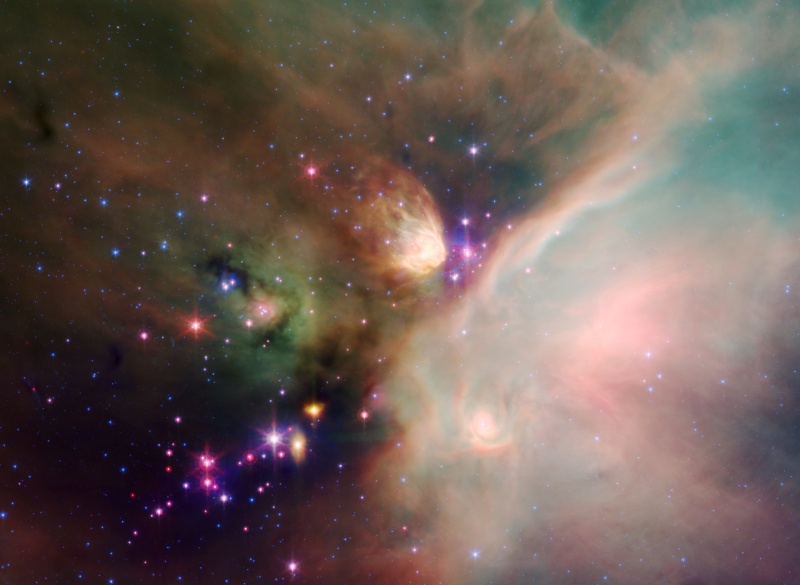 Im Bild sind Nebelschwaden verteilt, links dunkel, rechts hell, in den Farben rosabraun und türkis. Links unten leuchten Sterne eines Sternhaufens.