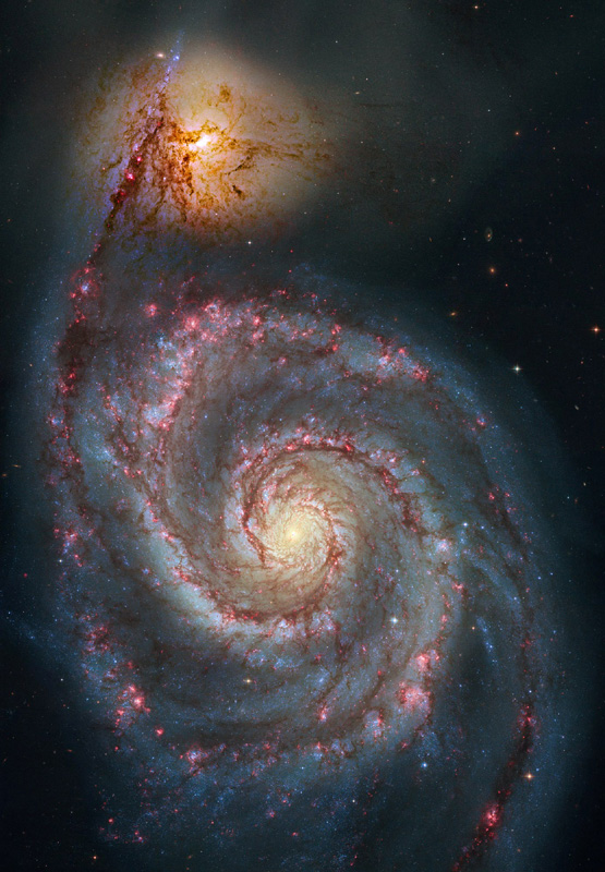Die Doppel-Spiralgalaxie ist bildfüllend dargestellt. Unten leuchtet die stark strukturierte größere Galaxie, ein Arm reicht nach oben zur kleineren, kaum strukturierten Galaxie.