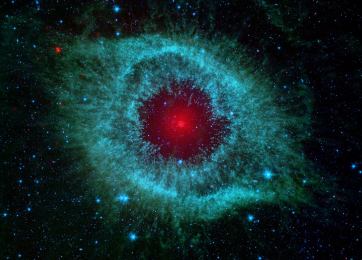 Ein grün leuchtender Nebel mit einem rot leuchtenden Stern in der Mitte erinnert an ein Auge.