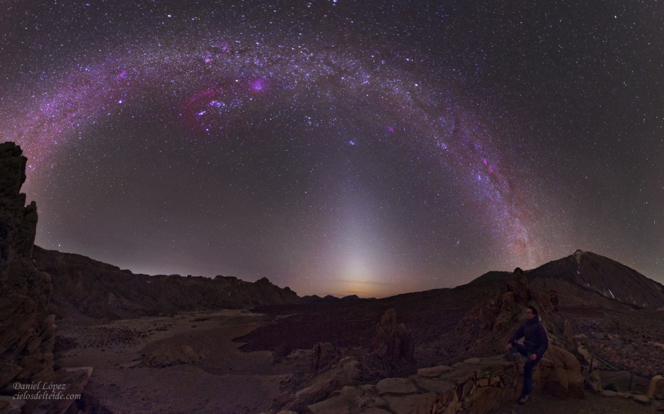 Über einer dunklen, zerklüfteten Berglandschaft wölbt sich die Milchstraße, oben steht das Sternbild Orion. In der Mitte steigt Zodiakallicht vom Horizont auf.