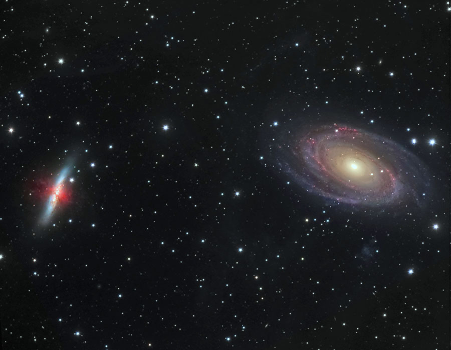 Links im Bild ist die irreguläre Galaxie M82 mit einem roten Nebel in der Mitte, rechts ist die schräg von oben sichtbare Spiralgalaxie M81 mit gelblichem Kern und ausgeprägten Spiralarmen.